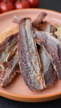 Atıştırmalık olarak kurutulmuş balık veya kurutulmuş et, dilimlenmiş deniz ürünleri. Tasarımınız için arka plan olarak kurutulmuş deniz ürünleri atıştırmalıkları