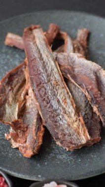 Atıştırmalık olarak kurutulmuş balık veya kurutulmuş et, dilimlenmiş deniz ürünleri. Tasarımınız için arka plan olarak kurutulmuş deniz ürünleri atıştırmalıkları