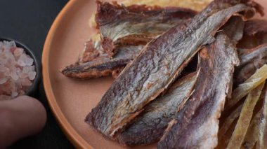 Atıştırmalık olarak kurutulmuş balık veya kurutulmuş et, dilimlenmiş deniz ürünleri. Tasarımınız için arka plan olarak kurutulmuş deniz ürünleri atıştırmalıkları