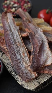 Atıştırmalık olarak kurutulmuş balık veya kurutulmuş et, dilimlenmiş deniz ürünleri. Tasarımınız için arka plan olarak kurutulmuş deniz ürünleri atıştırmalıkları