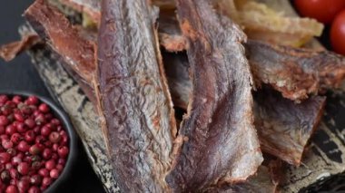 Atıştırmalık olarak kurutulmuş balık veya kurutulmuş et, dilimlenmiş deniz ürünleri. Tasarımınız için arka plan olarak kurutulmuş deniz ürünleri atıştırmalıkları