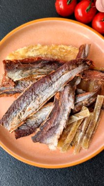 Atıştırmalık olarak kurutulmuş balık veya kurutulmuş et, dilimlenmiş deniz ürünleri. Tasarımınız için arka plan olarak kurutulmuş deniz ürünleri atıştırmalıkları