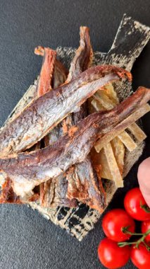 Atıştırmalık olarak kurutulmuş balık veya kurutulmuş et, dilimlenmiş deniz ürünleri. Tasarımınız için arka plan olarak kurutulmuş deniz ürünleri atıştırmalıkları