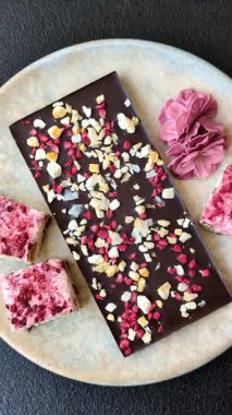 Evde kurutulmuş meyveli çikolatalı bir çikolata. Tasarımınız için arka plan olarak çikolatayı kullanın