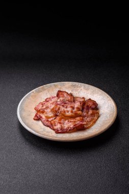 Sağlıklı bir kahvaltı için kızarmış domuz pastırması şeritleri. Tasarımınız için yiyecek olarak kızarmış pastırma şeritleri.