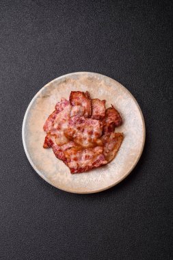 Sağlıklı bir kahvaltı için kızarmış domuz pastırması şeritleri. Tasarımınız için yiyecek olarak kızarmış pastırma şeritleri.