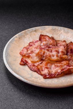 Sağlıklı bir kahvaltı için kızarmış domuz pastırması şeritleri. Tasarımınız için yiyecek olarak kızarmış pastırma şeritleri.