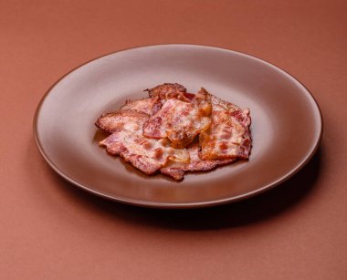 Sağlıklı bir kahvaltı için kızarmış domuz pastırması şeritleri. Tasarımınız için yiyecek olarak kızarmış pastırma şeritleri.