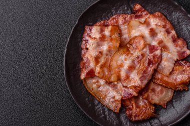 Sağlıklı bir kahvaltı için kızarmış domuz pastırması şeritleri. Tasarımınız için yiyecek olarak kızarmış pastırma şeritleri.