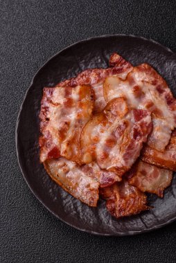 Sağlıklı bir kahvaltı için kızarmış domuz pastırması şeritleri. Tasarımınız için yiyecek olarak kızarmış pastırma şeritleri.