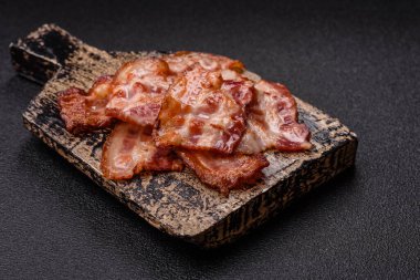 Sağlıklı bir kahvaltı için kızarmış domuz pastırması şeritleri. Tasarımınız için yiyecek olarak kızarmış pastırma şeritleri.