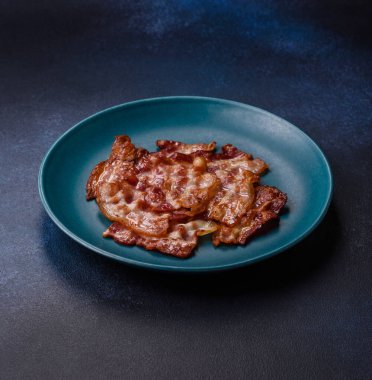 Sağlıklı bir kahvaltı için kızarmış domuz pastırması şeritleri. Tasarımınız için yiyecek olarak kızarmış pastırma şeritleri.