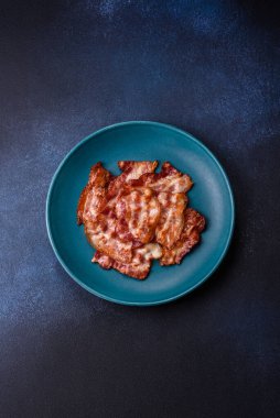 Sağlıklı bir kahvaltı için kızarmış domuz pastırması şeritleri. Tasarımınız için yiyecek olarak kızarmış pastırma şeritleri.