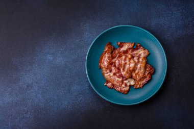 Sağlıklı bir kahvaltı için kızarmış domuz pastırması şeritleri. Tasarımınız için yiyecek olarak kızarmış pastırma şeritleri.