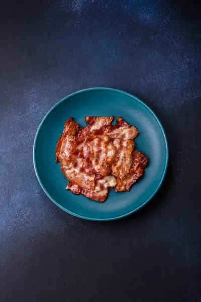 Sağlıklı bir kahvaltı için kızarmış domuz pastırması şeritleri. Tasarımınız için yiyecek olarak kızarmış pastırma şeritleri.