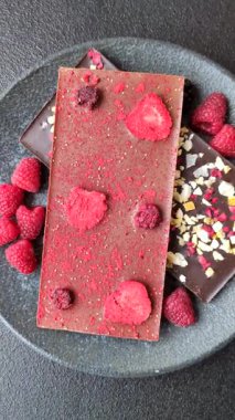 Evde kurutulmuş meyveli çikolatalı bir çikolata. Tasarımınız için arka plan olarak çikolatayı kullanın