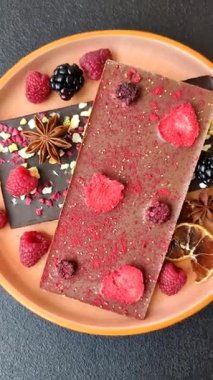 Evde kurutulmuş meyveli çikolatalı bir çikolata. Tasarımınız için arka plan olarak çikolatayı kullanın