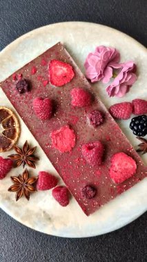 Evde kurutulmuş meyveli çikolatalı bir çikolata. Tasarımınız için arka plan olarak çikolatayı kullanın