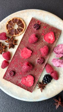 Evde kurutulmuş meyveli çikolatalı bir çikolata. Tasarımınız için arka plan olarak çikolatayı kullanın