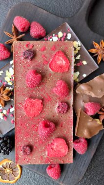 Evde kurutulmuş meyveli çikolatalı bir çikolata. Tasarımınız için arka plan olarak çikolatayı kullanın