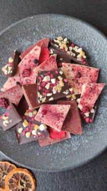 Evde kurutulmuş meyveli çikolatalı bir çikolata. Tasarımınız için arka plan olarak çikolatayı kullanın