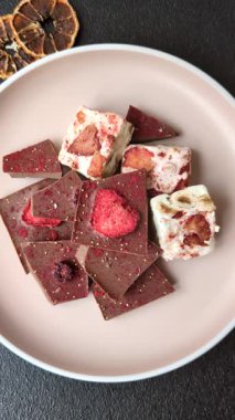 Evde kurutulmuş meyveli çikolatalı bir çikolata. Tasarımınız için arka plan olarak çikolatayı kullanın