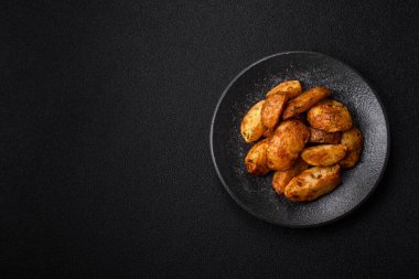 Baharatlı, sarımsaklı ve biberiyeli patates dilimleri. Tasarımınız için yemek arkaplanı olarak patates dilimleri