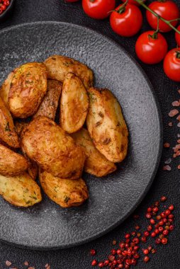 Baharatlı, sarımsaklı ve biberiyeli patates dilimleri. Tasarımınız için yemek arkaplanı olarak patates dilimleri