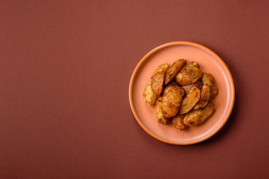 Baharatlı, sarımsaklı ve biberiyeli patates dilimleri. Tasarımınız için yemek arkaplanı olarak patates dilimleri