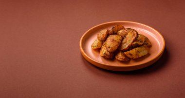 Baharatlı, sarımsaklı ve biberiyeli patates dilimleri. Tasarımınız için yemek arkaplanı olarak patates dilimleri