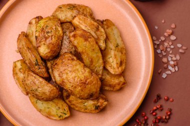 Baharatlı, sarımsaklı ve biberiyeli patates dilimleri. Tasarımınız için yemek arkaplanı olarak patates dilimleri