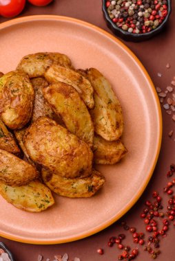 Baharatlı, sarımsaklı ve biberiyeli patates dilimleri. Tasarımınız için yemek arkaplanı olarak patates dilimleri