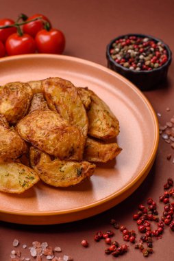 Baharatlı, sarımsaklı ve biberiyeli patates dilimleri. Tasarımınız için yemek arkaplanı olarak patates dilimleri