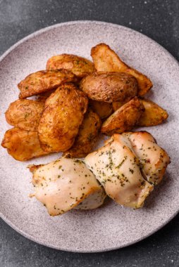 Baharatlı, sarımsaklı ve biberiyeli patates dilimleri. Tasarımınız için yemek arkaplanı olarak patates dilimleri