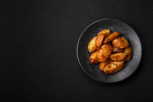 Baharatlı, sarımsaklı ve biberiyeli patates dilimleri. Tasarımınız için yemek arkaplanı olarak patates dilimleri