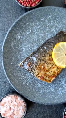 Yiyecek, deniz ürünleri, limon, tuz ve baharatlı ızgara balık filetosu. Öğle yemeği için ızgara balık filetosu, sağlıklı yemek.