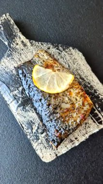 Yiyecek, deniz ürünleri, limon, tuz ve baharatlı ızgara balık filetosu. Öğle yemeği için ızgara balık filetosu, sağlıklı yemek.