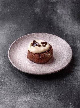 Cinnamon roll, a sweet bun with citrus, cherries, and chocolate, a Danish dessert with cream. Cinnamon roll as a food background for your design