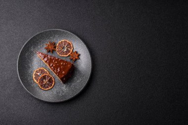 A slice of sweet layered cake covered in chocolate with nuts and caramel. A slice of chocolate cake as a food background for your design.