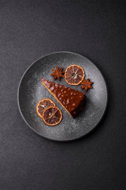 A slice of sweet layered cake covered in chocolate with nuts and caramel. A slice of chocolate cake as a food background for your design.