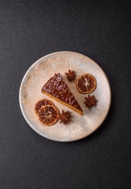 A slice of sweet layered cake covered in chocolate with nuts and caramel. A slice of chocolate cake as a food background for your design.