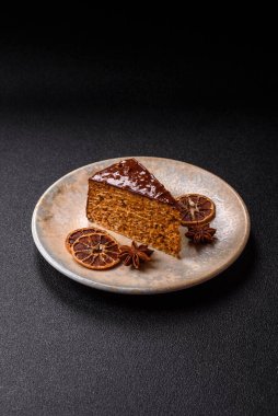 A slice of sweet layered cake covered in chocolate with nuts and caramel. A slice of chocolate cake as a food background for your design.