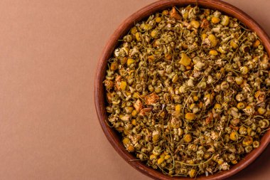 Dried chamomile flowers, herbal tea in a bowl for a hot morning drink. Dried chamomile as a background for your design.