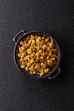 Dried chamomile flowers, herbal tea in a bowl for a hot morning drink. Dried chamomile as a background for your design.