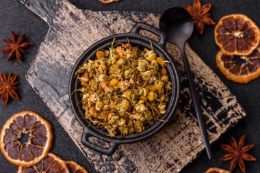 Dried chamomile flowers, herbal tea in a bowl for a hot morning drink. Dried chamomile as a background for your design.