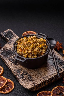 Dried chamomile flowers, herbal tea in a bowl for a hot morning drink. Dried chamomile as a background for your design.