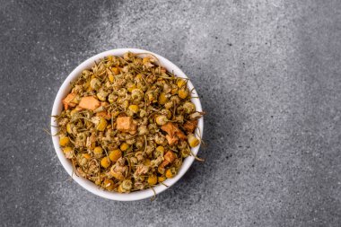 Dried chamomile flowers, herbal tea in a bowl for a hot morning drink. Dried chamomile as a background for your design.