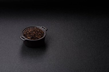 Golden black tea, dried leaves of a Chinese or Indian breakfast drink. Black tea dried leaves as a food backdrop for your design