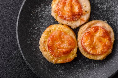 Domates ve peynirle pişirilmiş yuvarlak balık ya da tavuk pirzolası. Tasarımınız için yemek arkaplanı olarak balık pirzolası