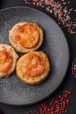 Domates ve peynirle pişirilmiş yuvarlak balık ya da tavuk pirzolası. Tasarımınız için yemek arkaplanı olarak balık pirzolası